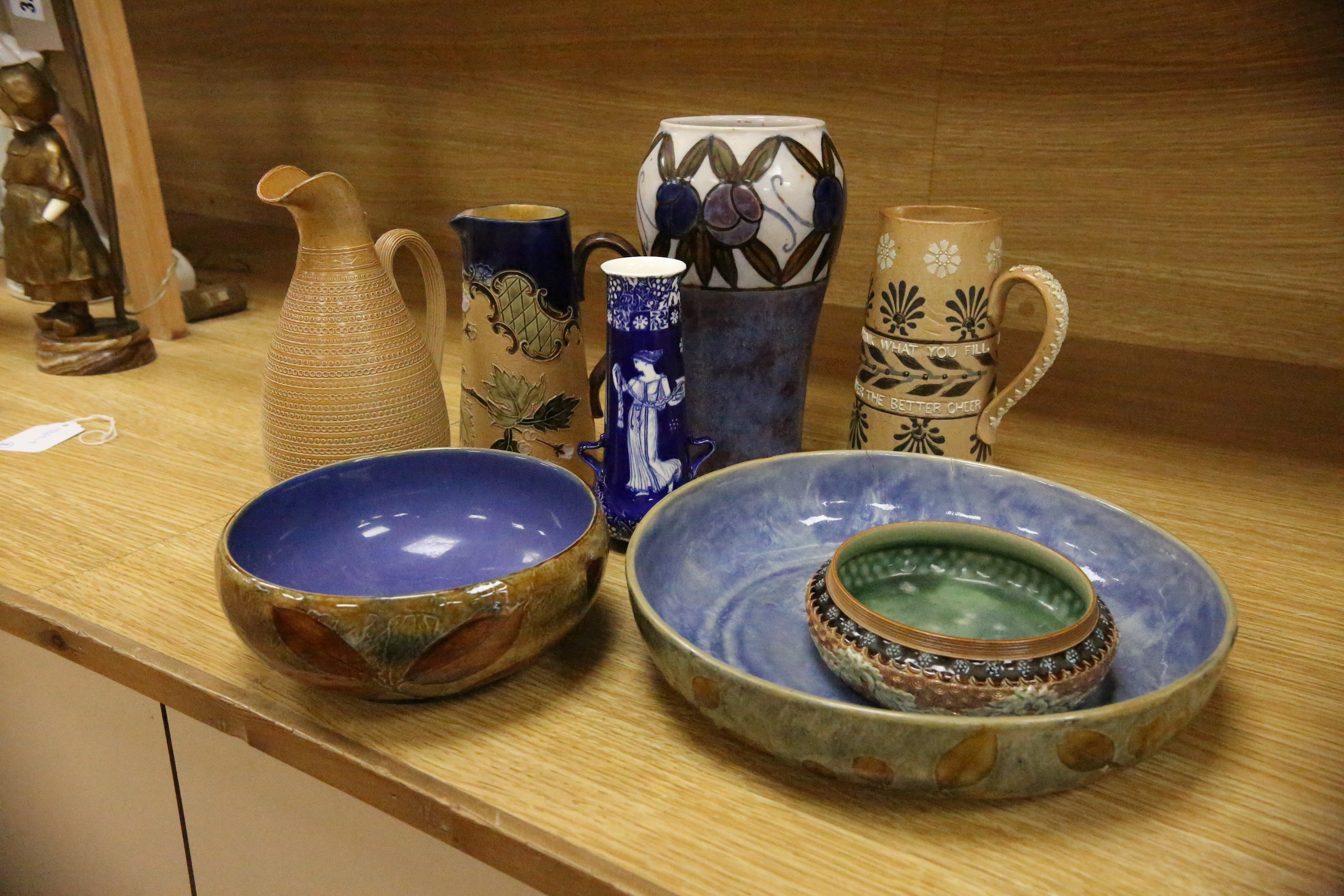 Three Royal Doulton jugs, two vases and two natural foliage ware dishes, tallest vase 23cm high. Condition - smallest jug cracked near rim, two handled vase glazing blemish near base